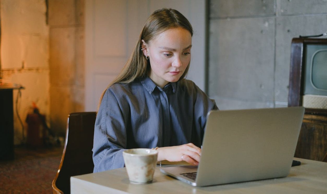 Serious female freelancer using netbook in workspace