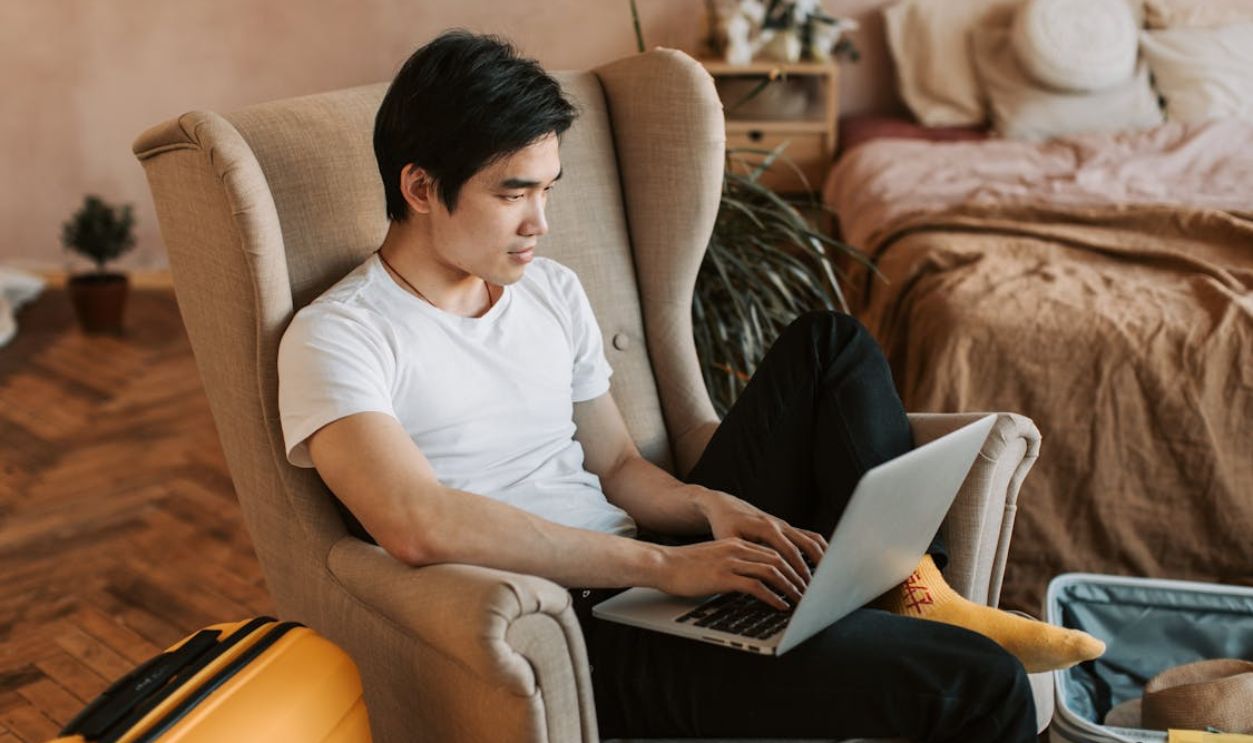 Man Sitting in an Armchair and Using Laptop