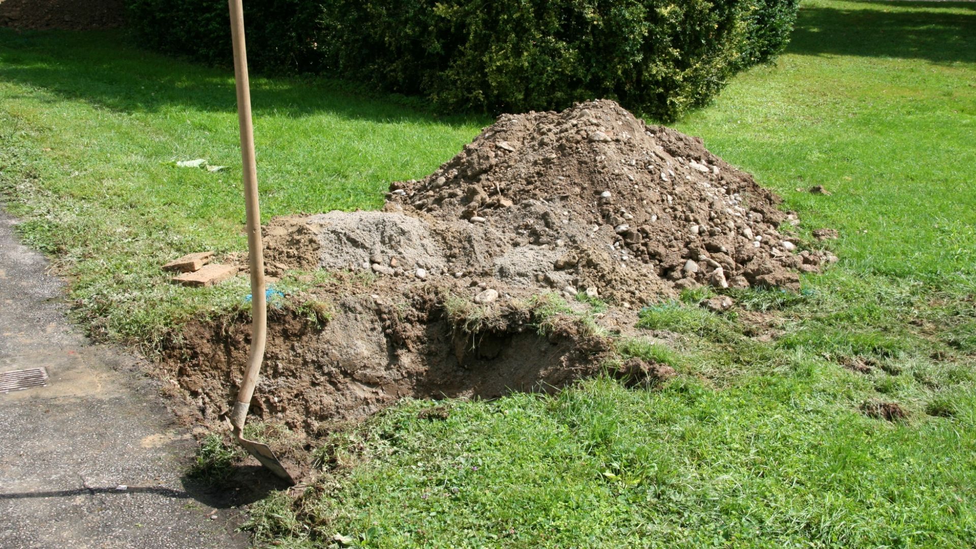 Digging a hole with a shovel. Hole dug in garden lawn with a gardening tool. Garden earthworks.