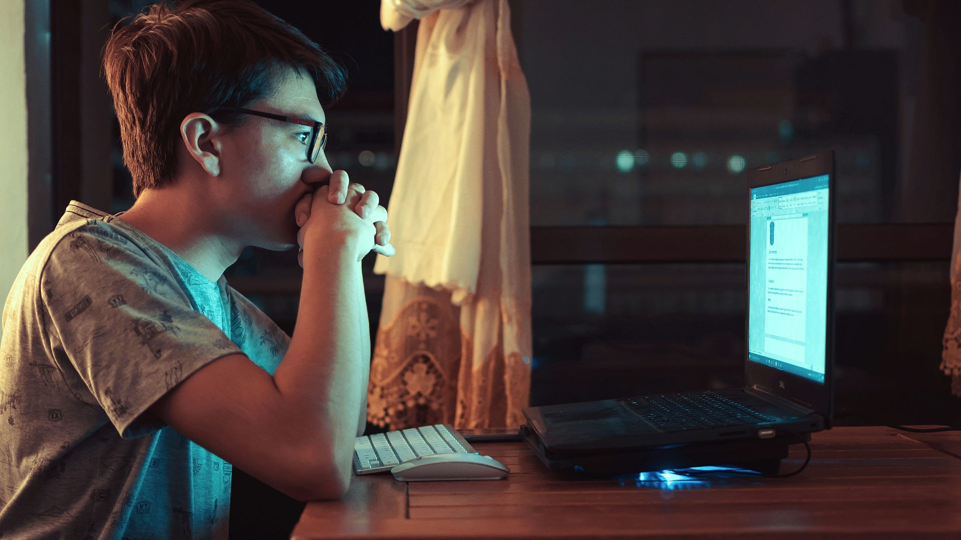 woman in brown shirt sitting in front of laptop computer