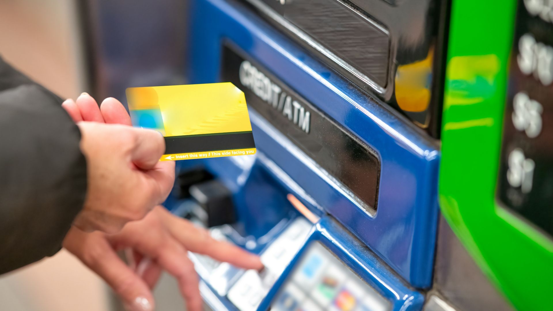 a person using a credit card to pay for a machine