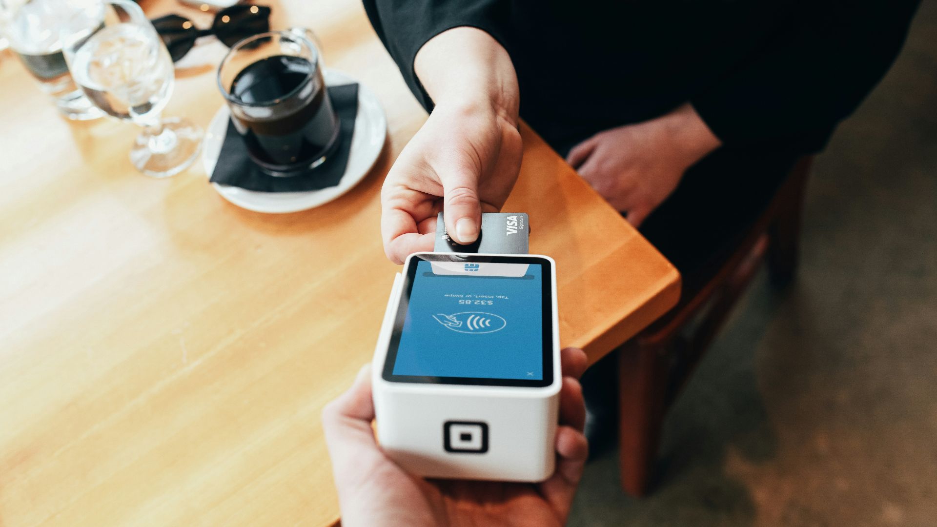 person holding credit card swipe machine