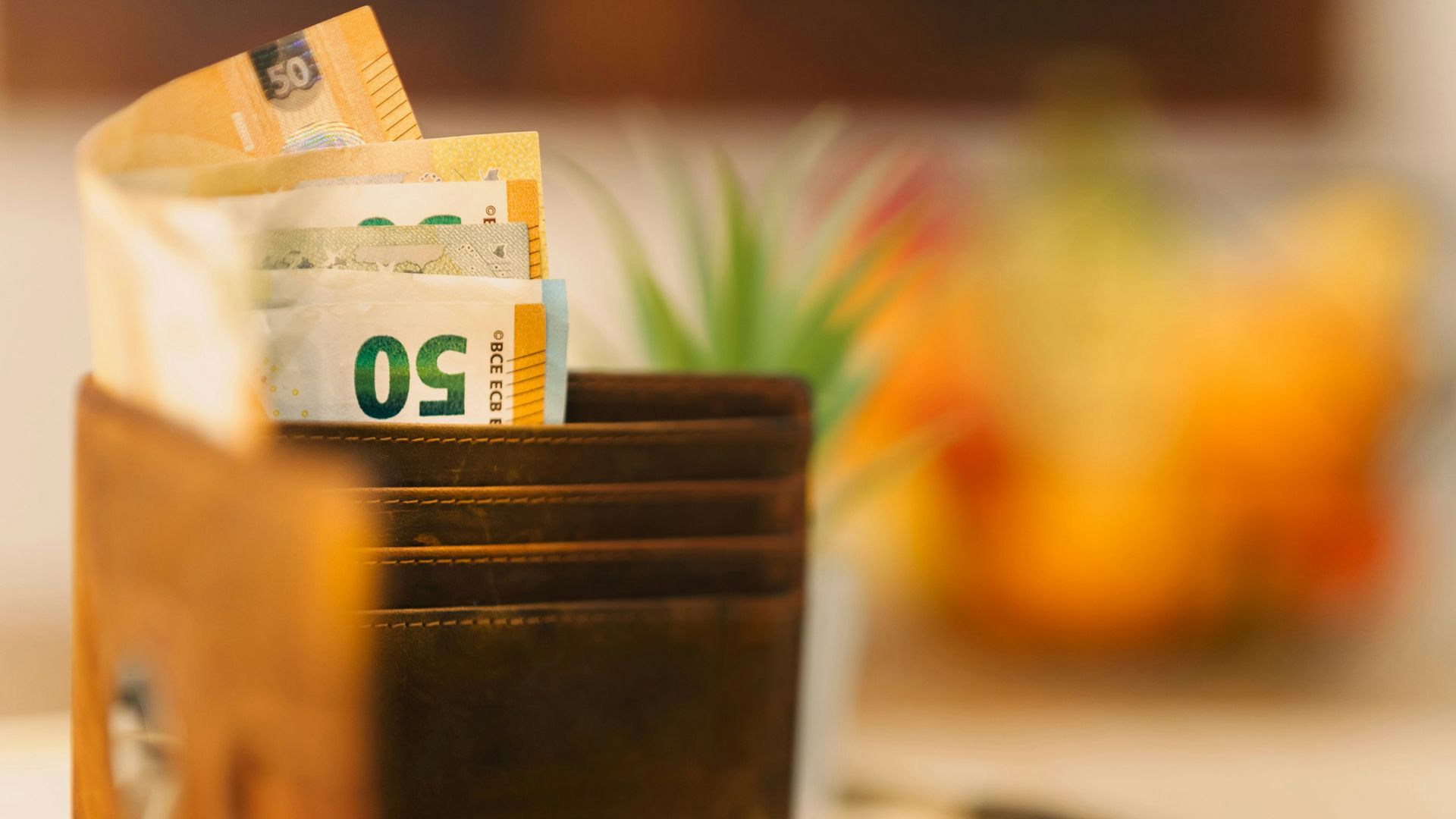 A wallet sitting on top of a table filled with money