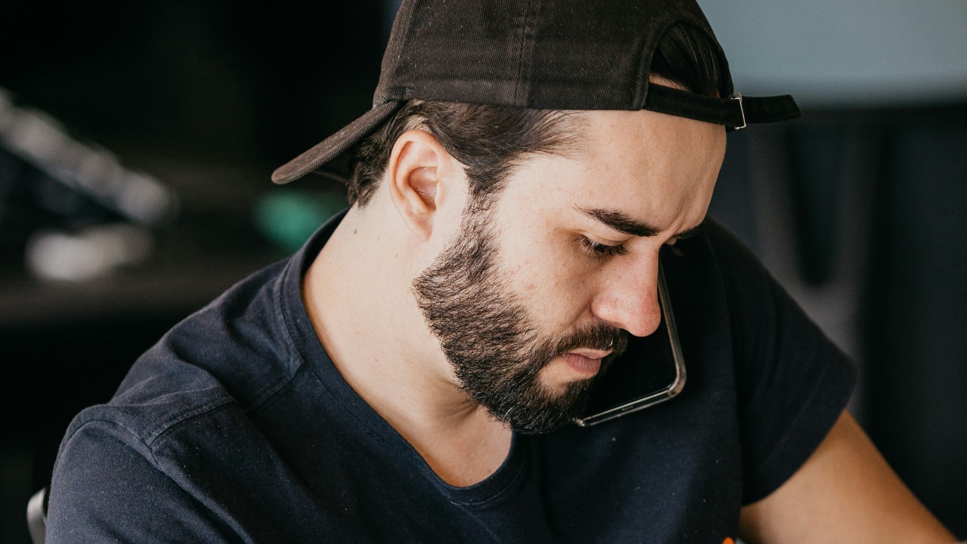 a man with a beard looking at a computer monitor
