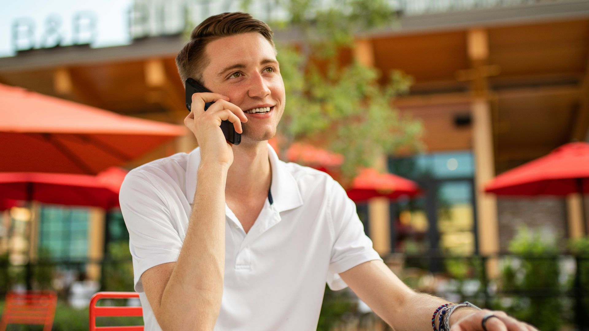 man in white crew neck t-shirt sitting on red bench
