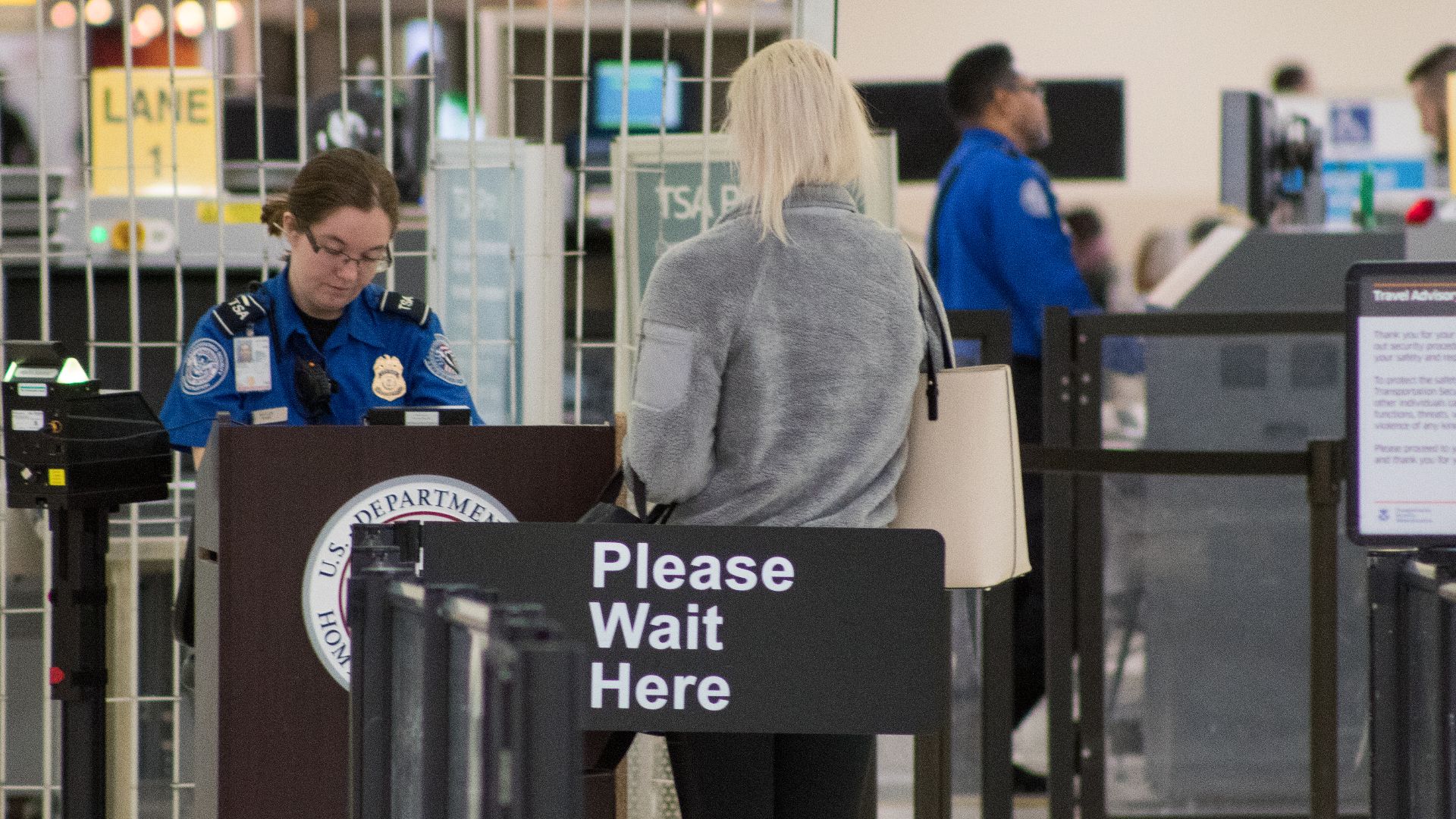A Transportation Security Administration agent at a checkpoint verifying passenger identification, John Glenn Columbus International Airport