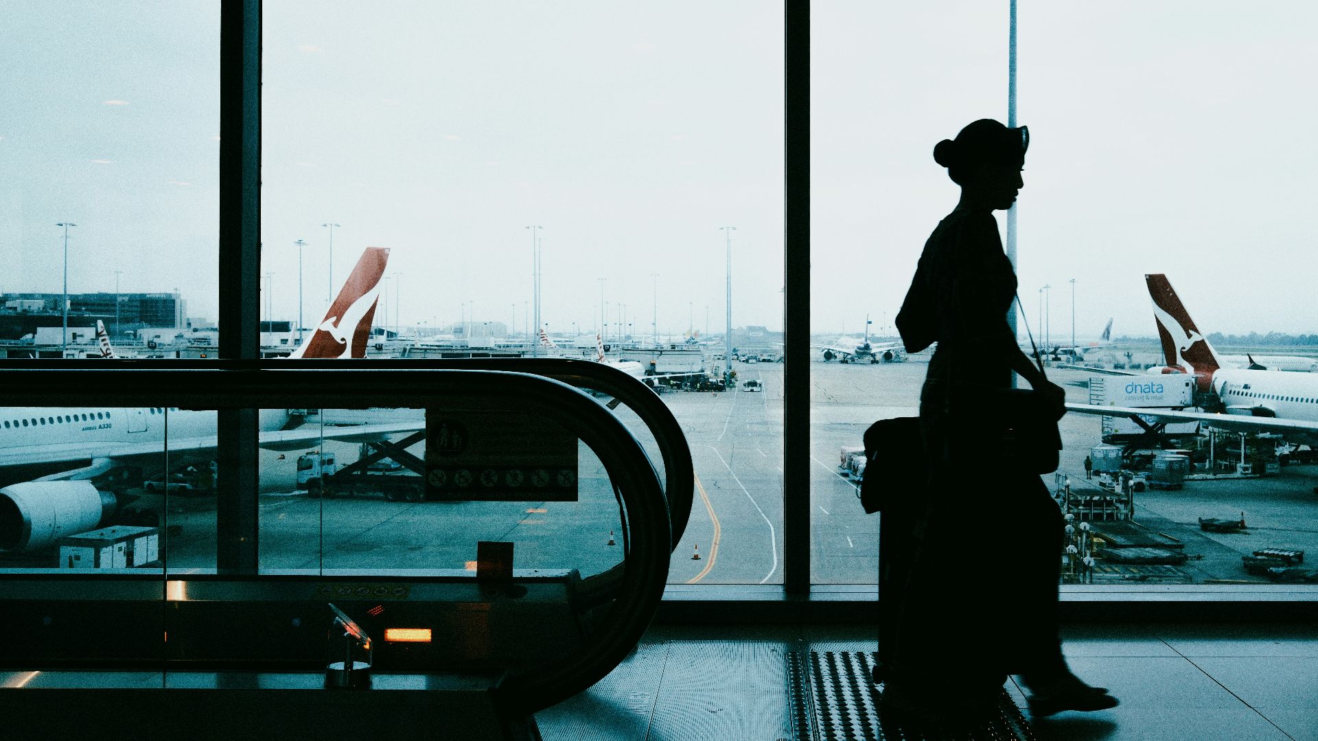 Silhouette of a woman with suitcase at airport