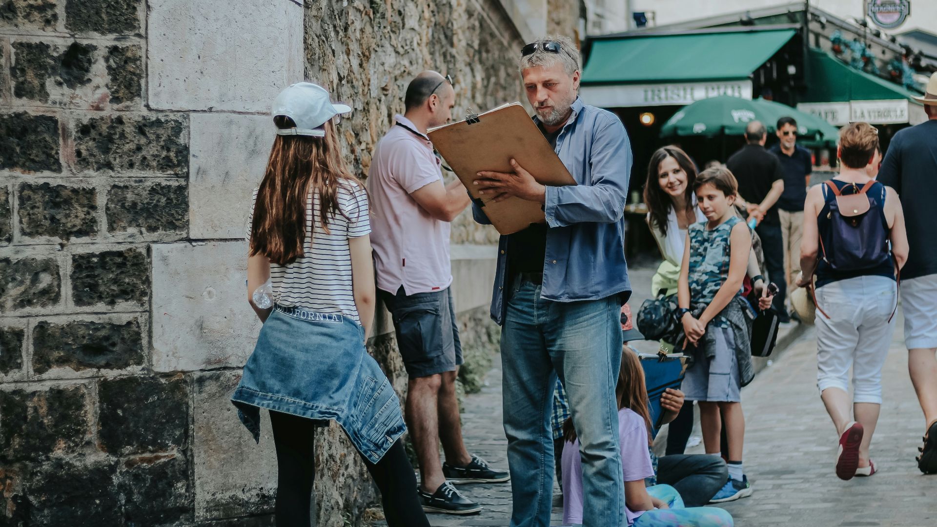 man holding clipboard talking to girl