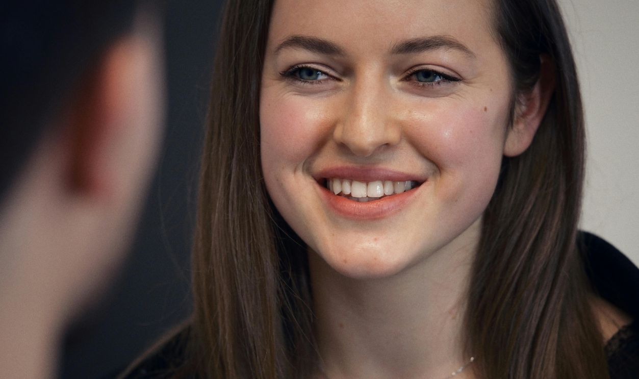Woman Smiling During a Friendly Conversation