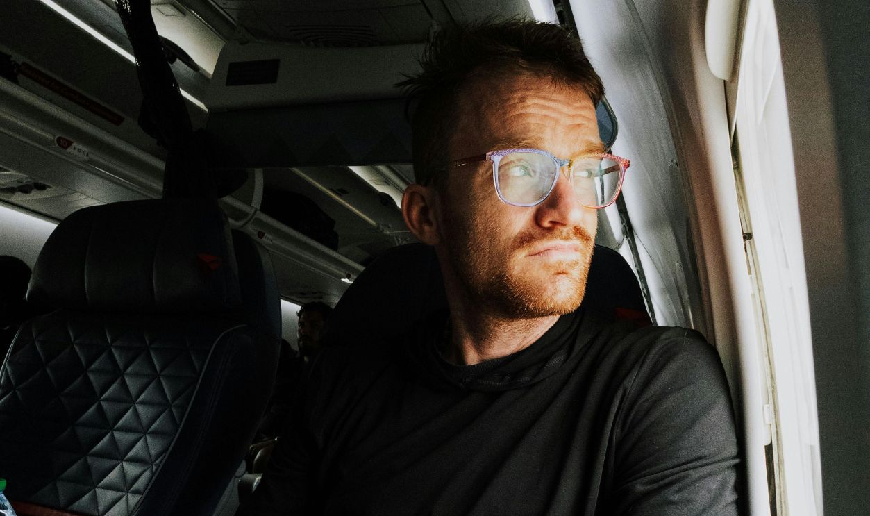 Man Gazing Out Plane Window During Flight