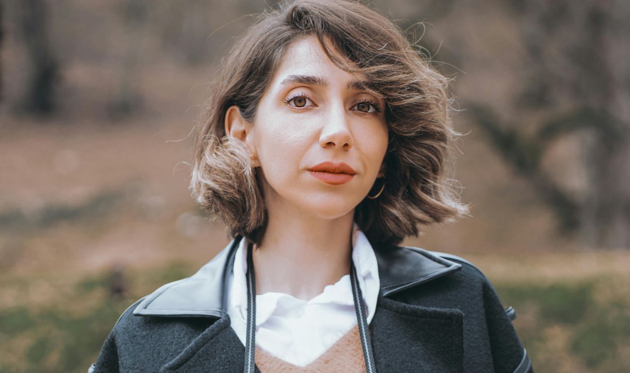 Brunette Woman with Camera Posing in Park