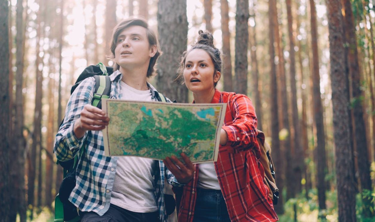 Young Couple Exploring Forest with Map