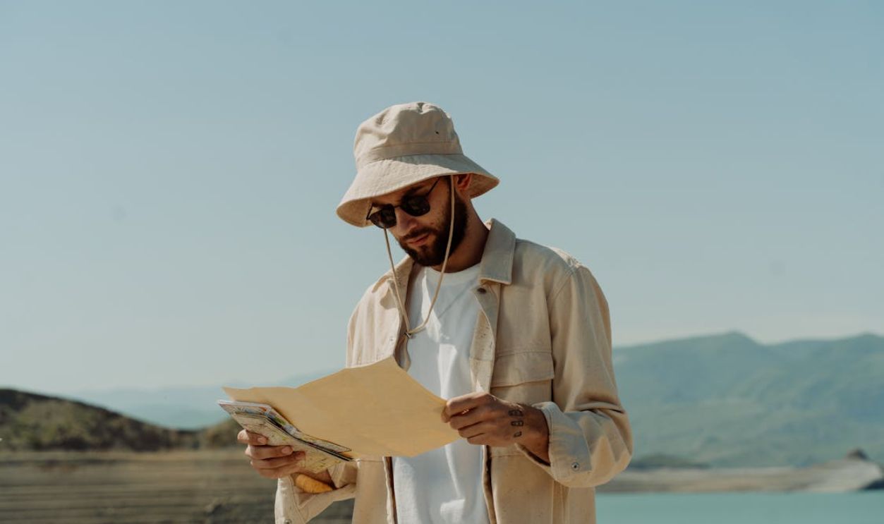 Photo of a Man with a Bucket Holding a Map