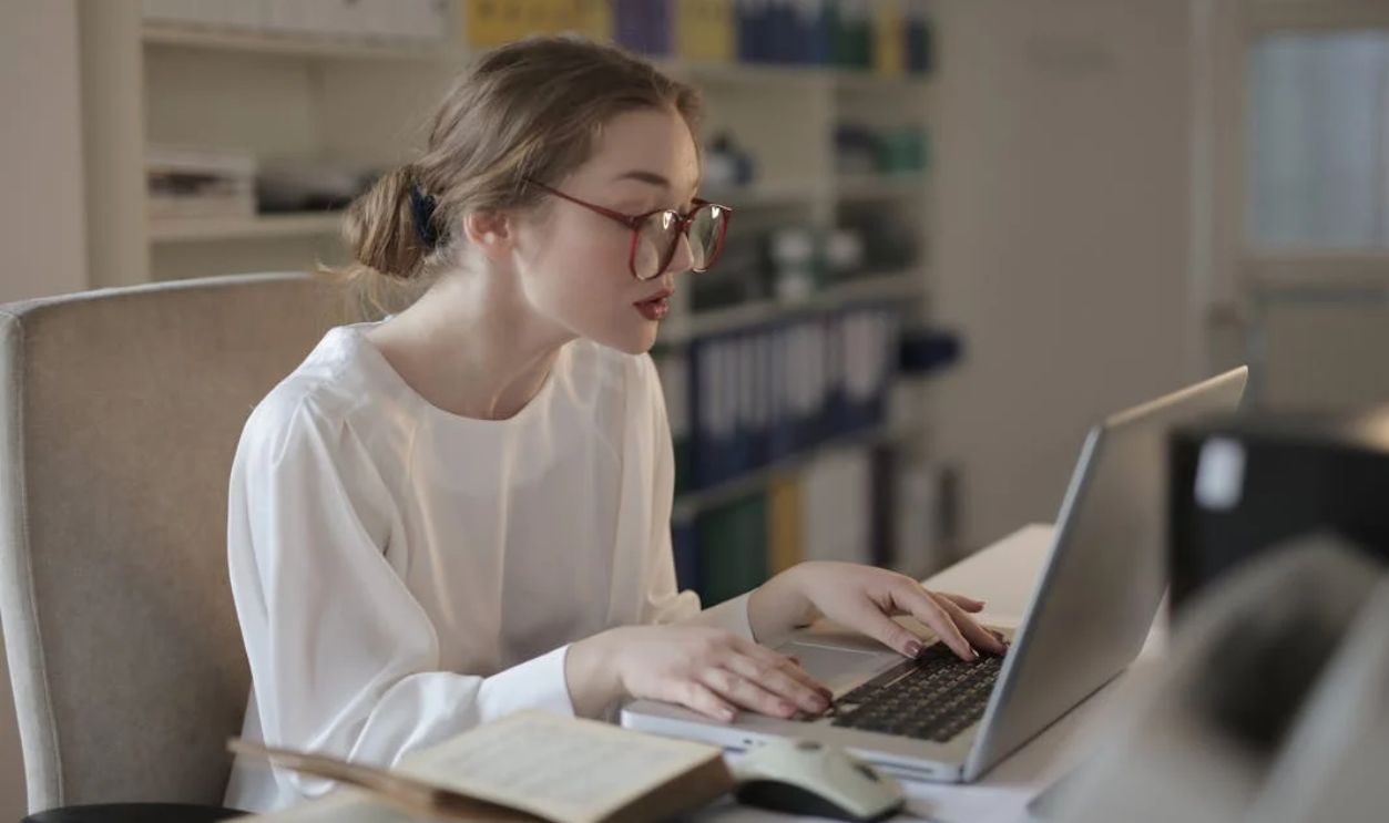 Woman In White Dress Shirt Using A Laptop