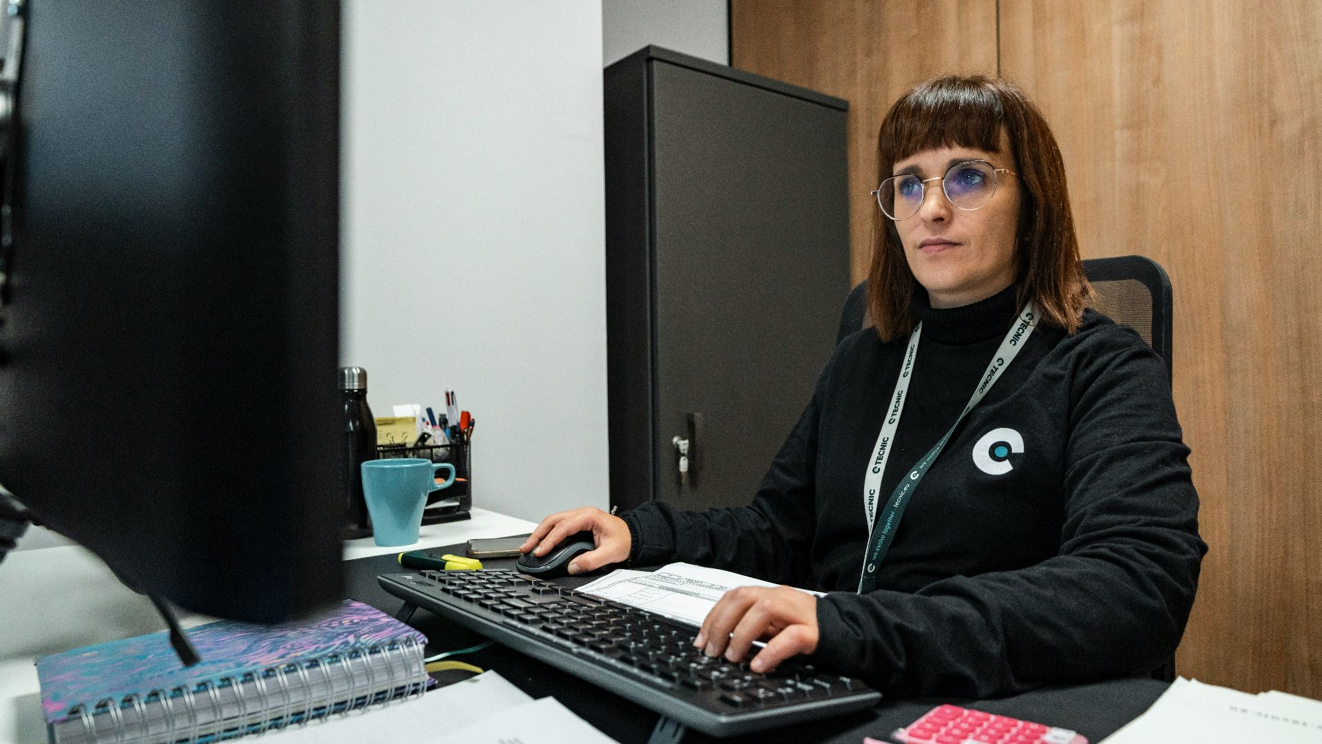 A woman is working at her office desk.