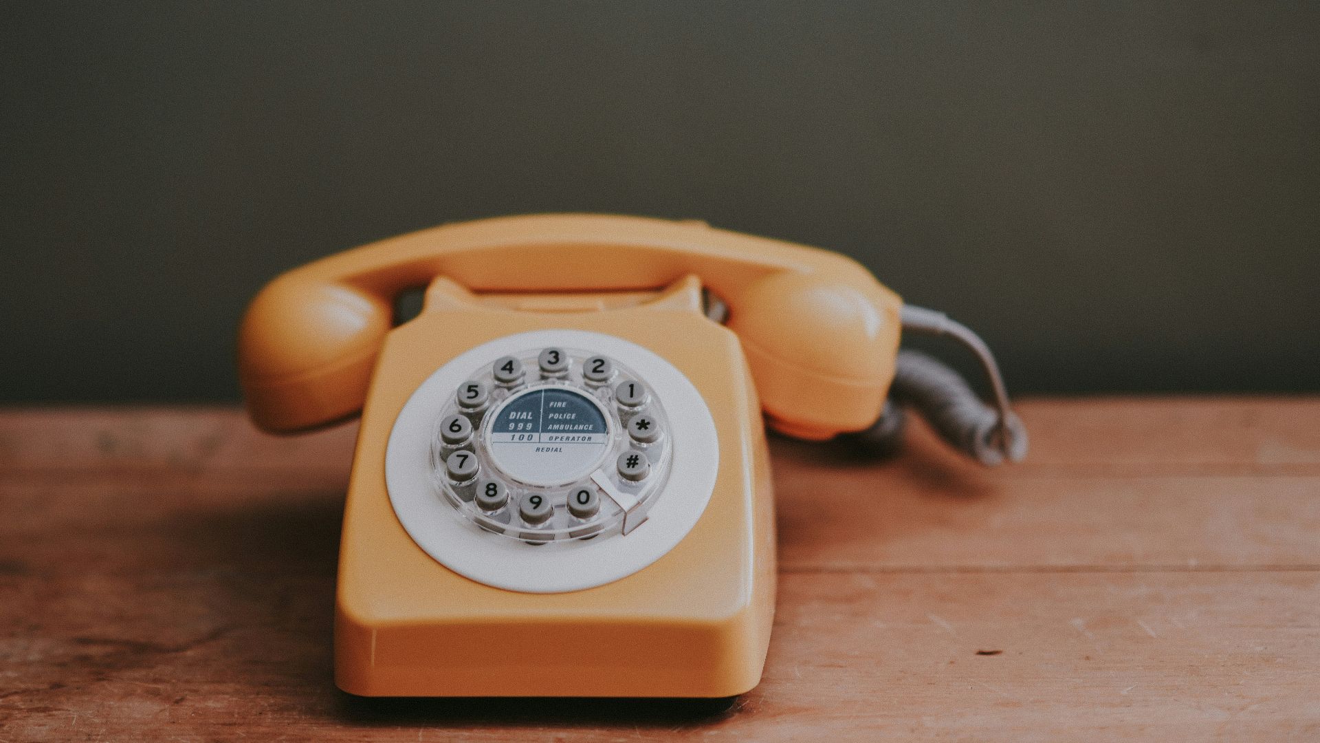 brown rotary dial telephone in gray painted room