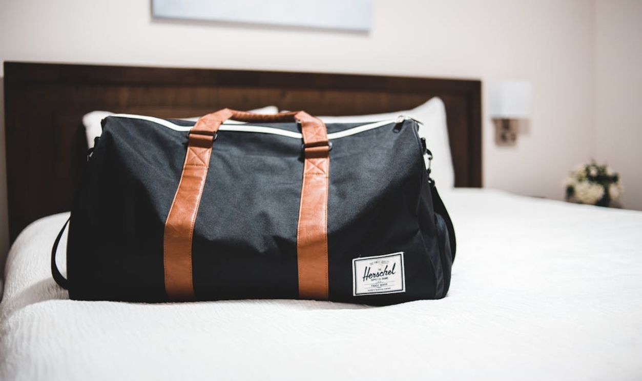 Modern sports bag on bed in hotel room