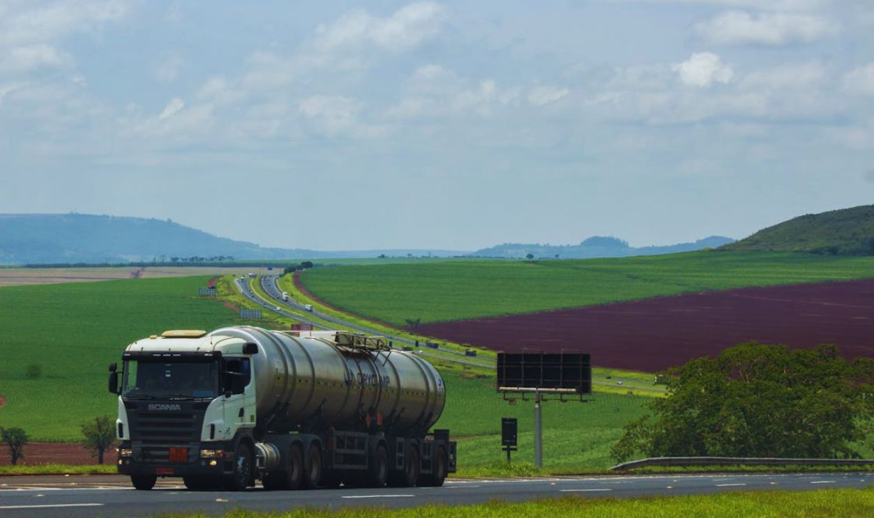 Truck Driving through Countryside under Blue Sky