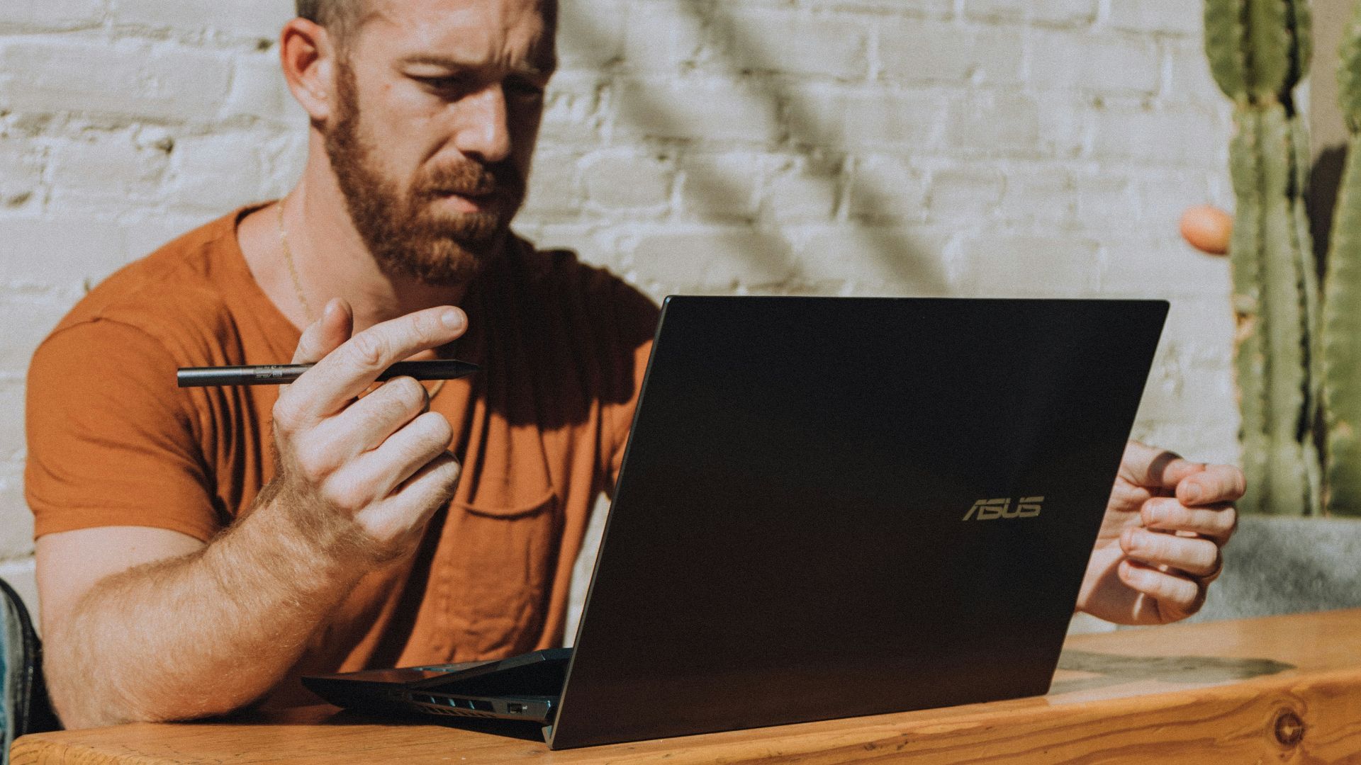 a man sitting at a table using a laptop computer