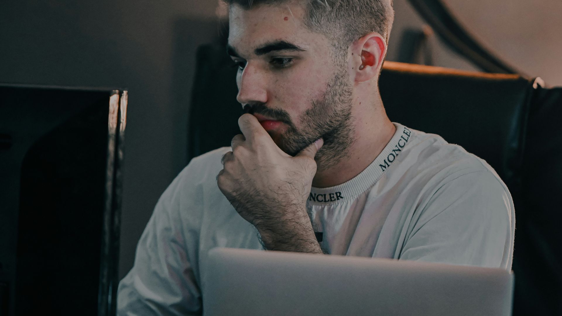 a man with a beard looking at a laptop