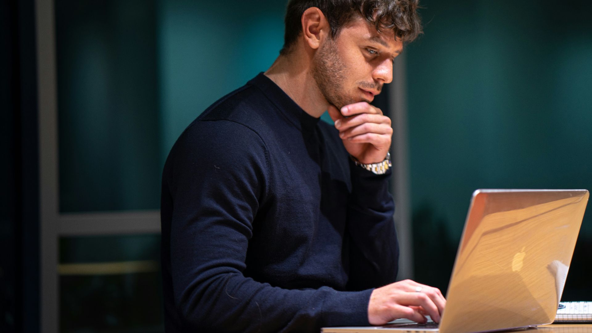 man in black long sleeve shirt sitting in front of macbook