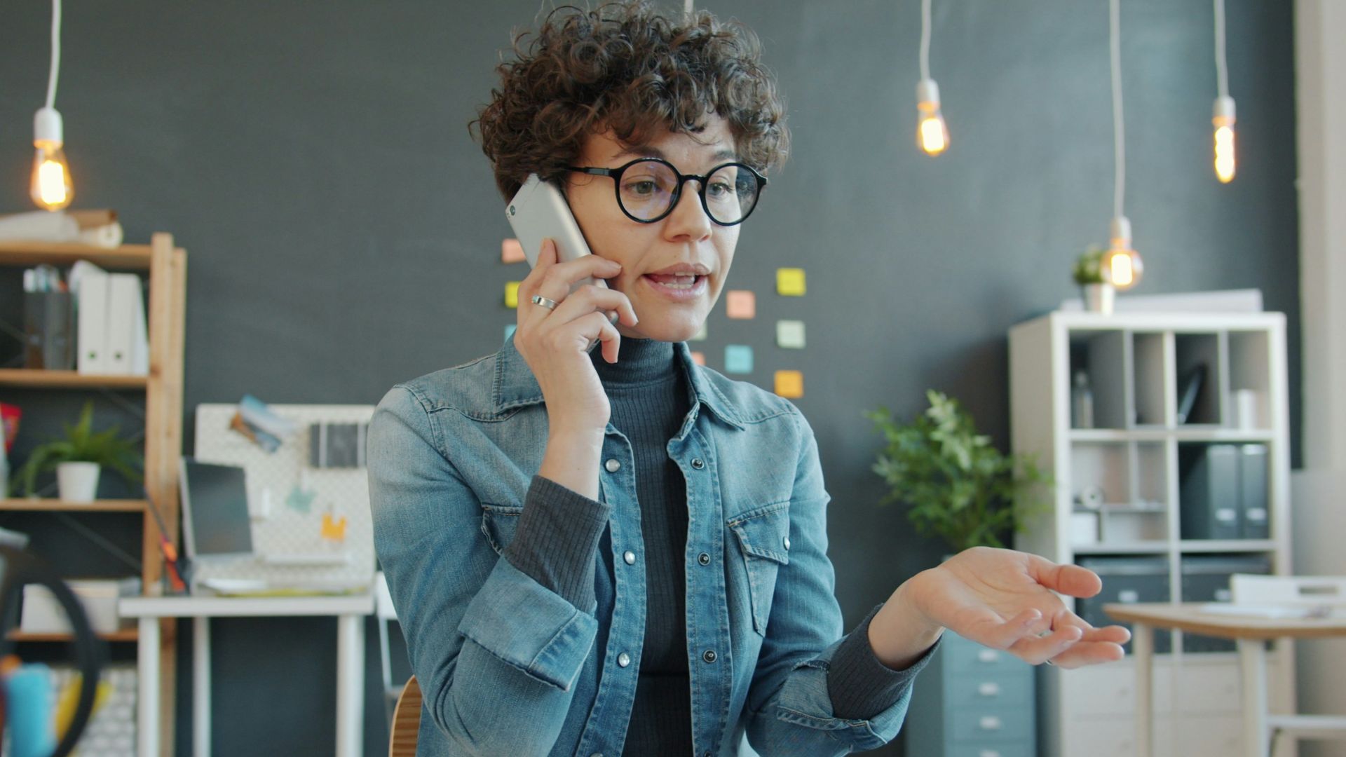 Woman talking on phone at desk in office