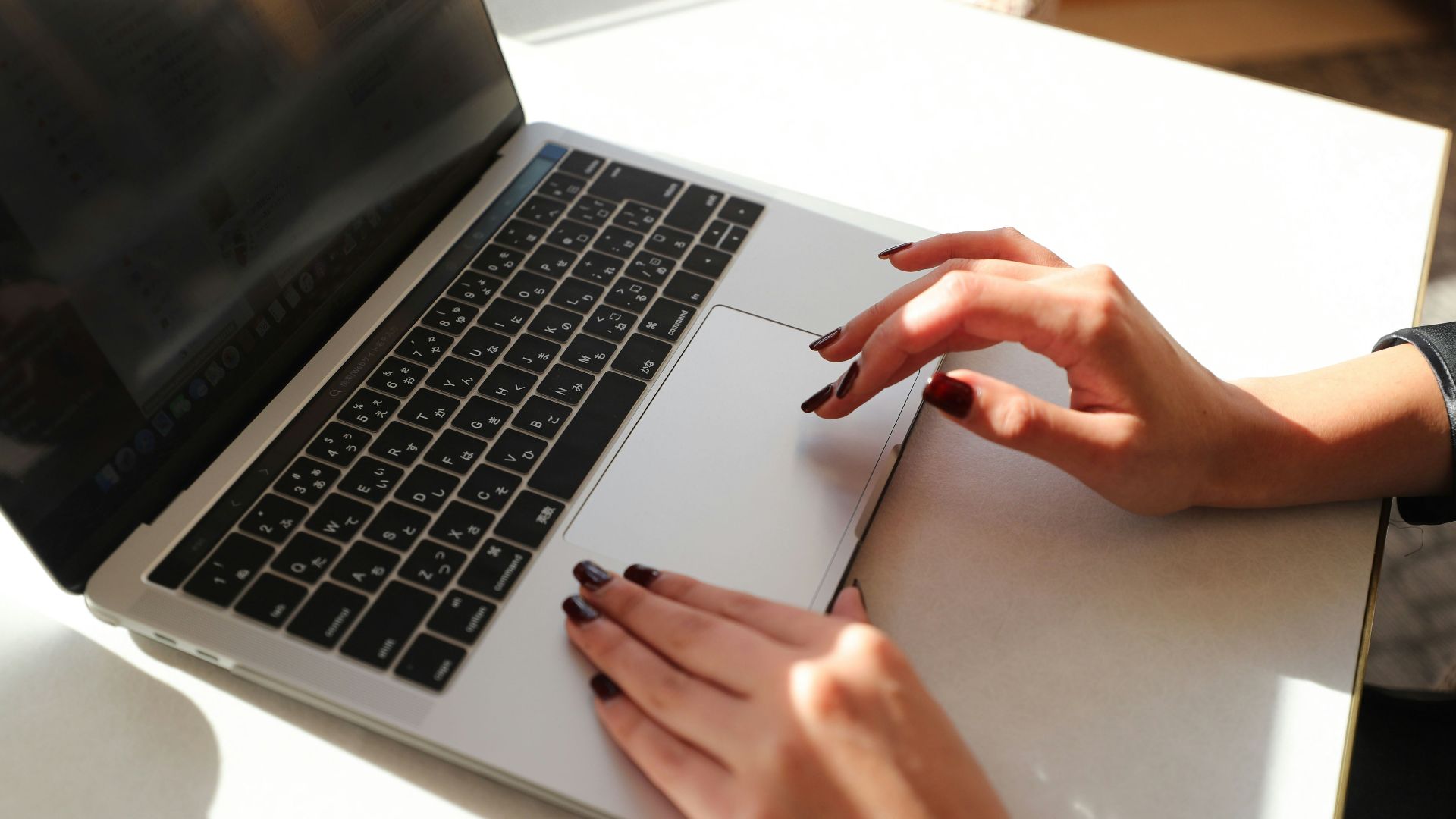 A woman sitting at a table using a laptop computer