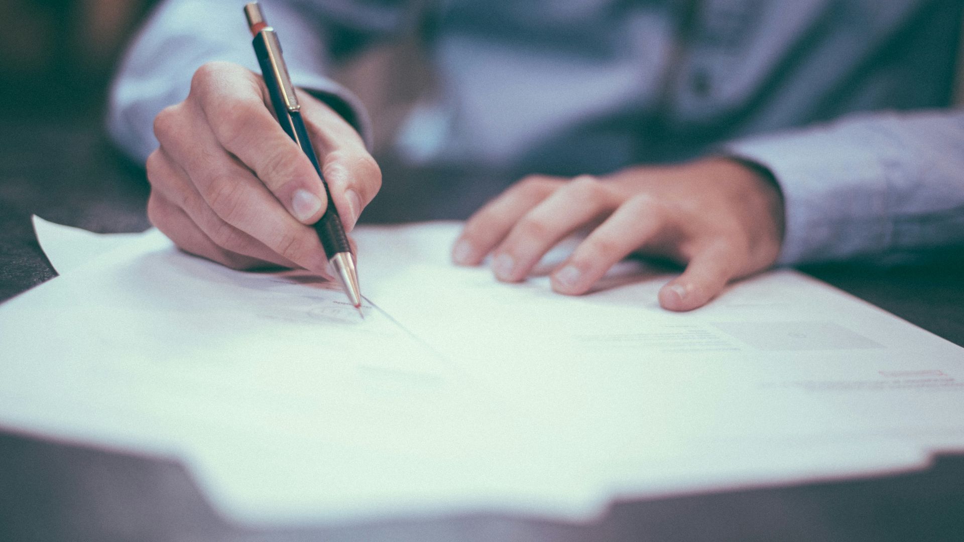 man writing on paper