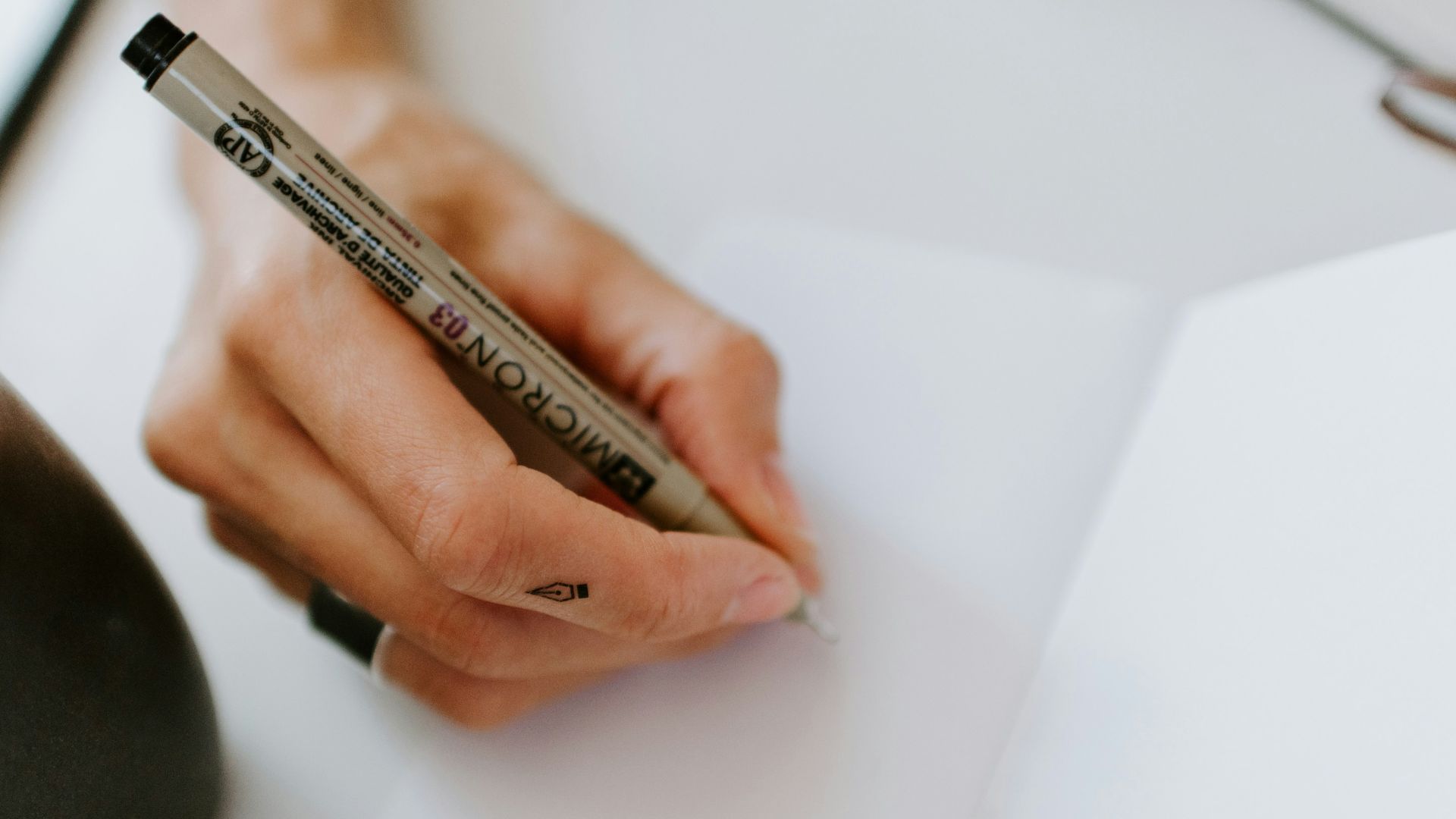 person using pen on white paper