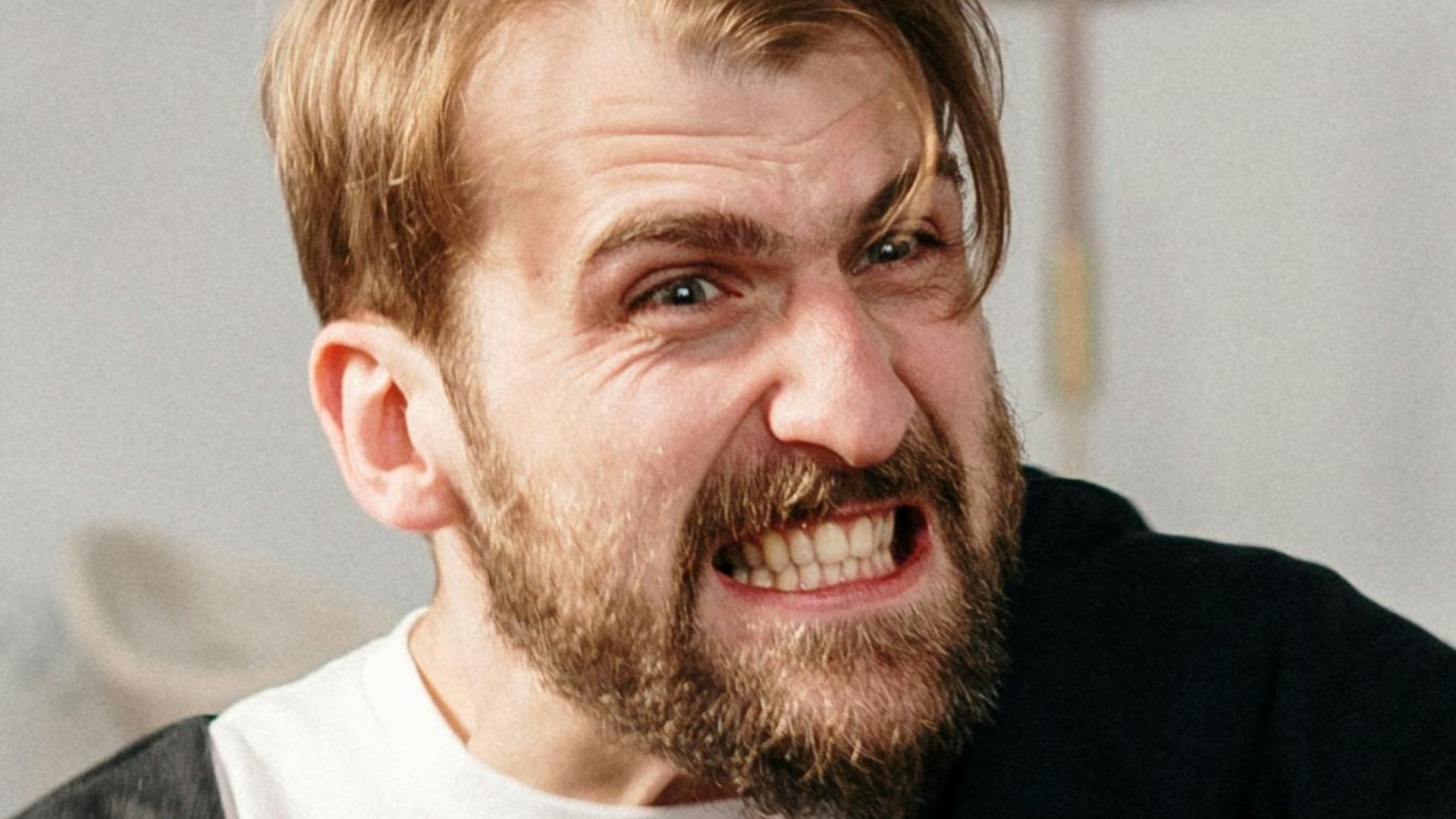 An angry man expressing emotion during a therapy session indoors.