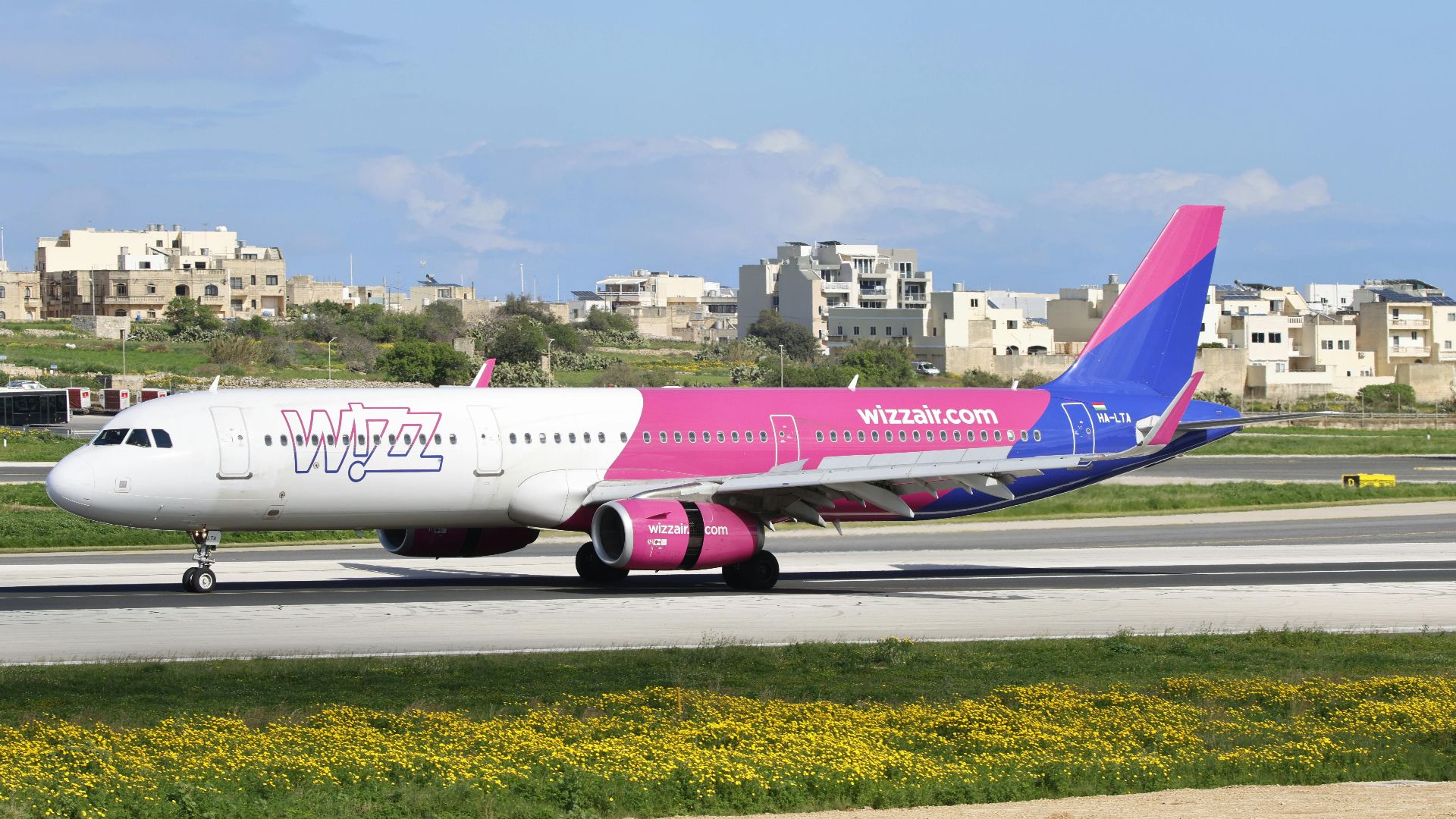 Vibrant aircraft on airport runway with clear skies.