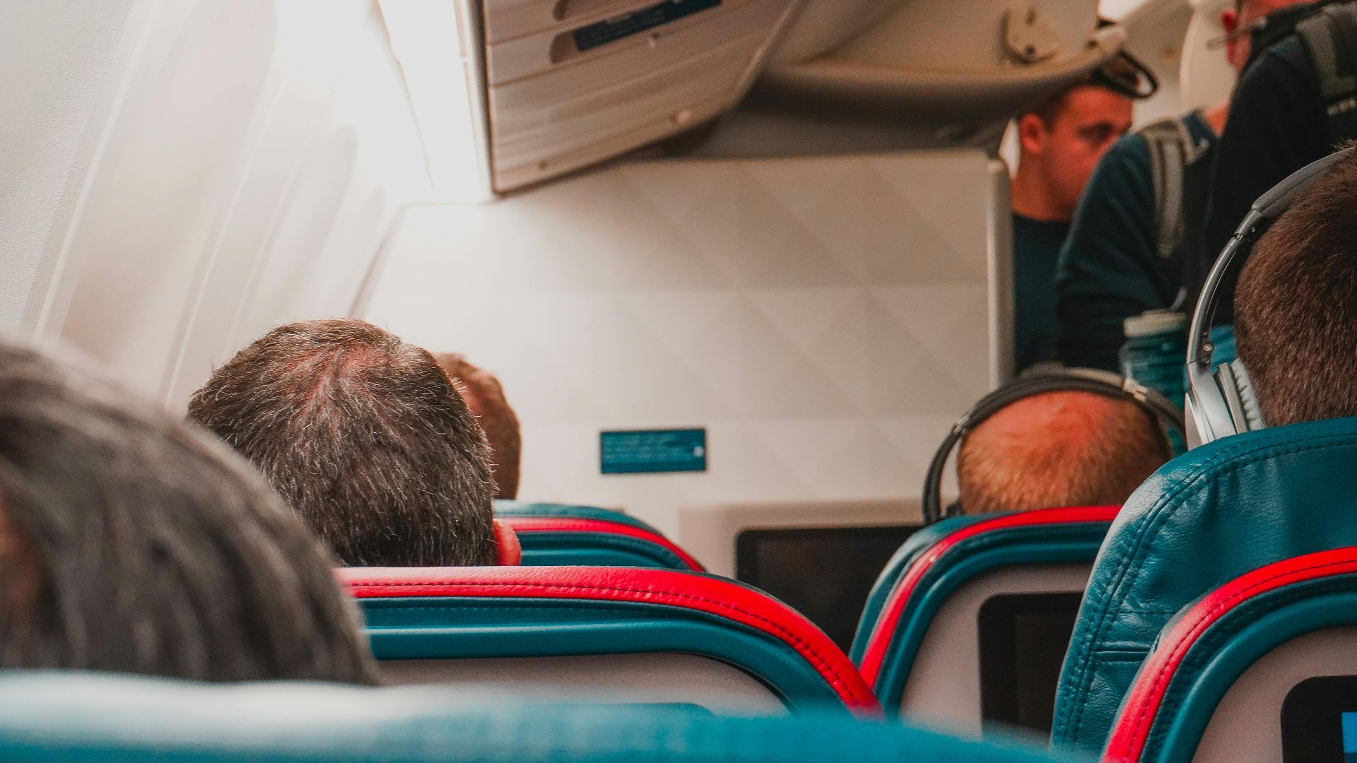 Interior view of an airplane cabin with passengers seated, focusing on seats and layout.