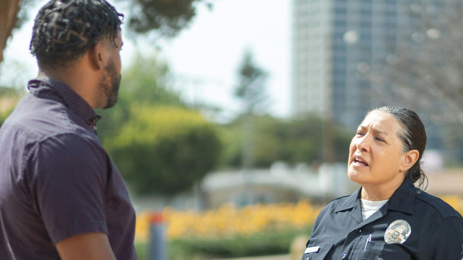 A police officer in uniform converses with a man on a sunny day, showcasing community engagement.