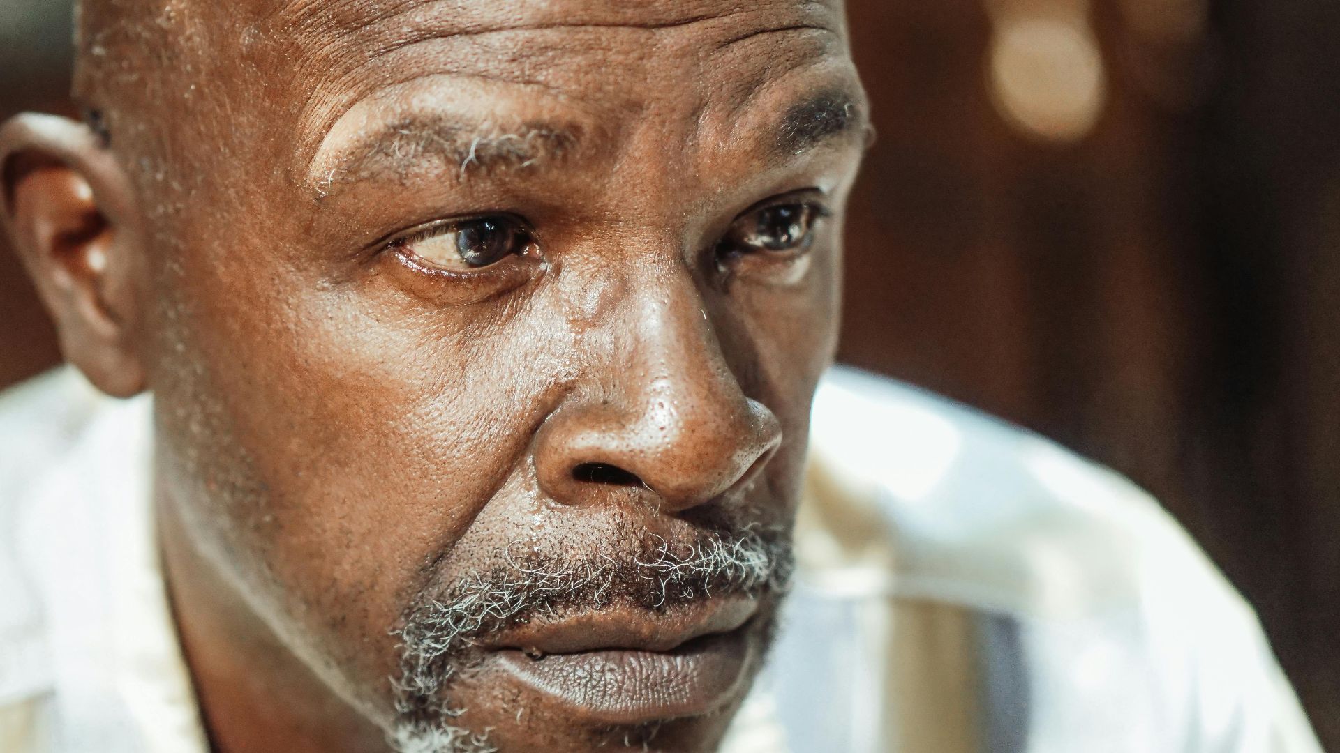 Close-up portrait of an elderly man with a contemplative expression, highlighting emotions of introspection and reflection.