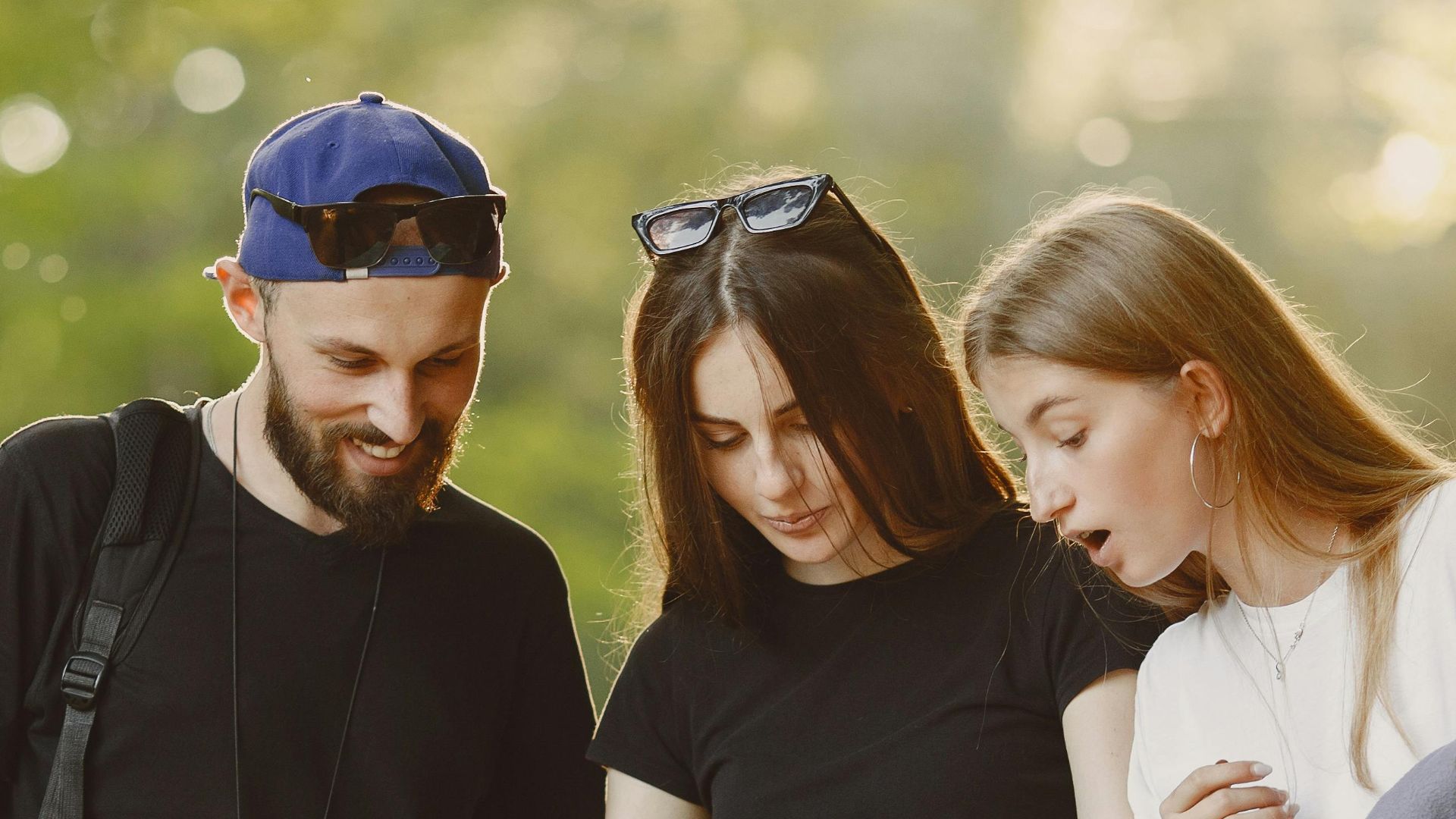A group of friends navigating a forest trail with a map, enjoying a summer adventure.