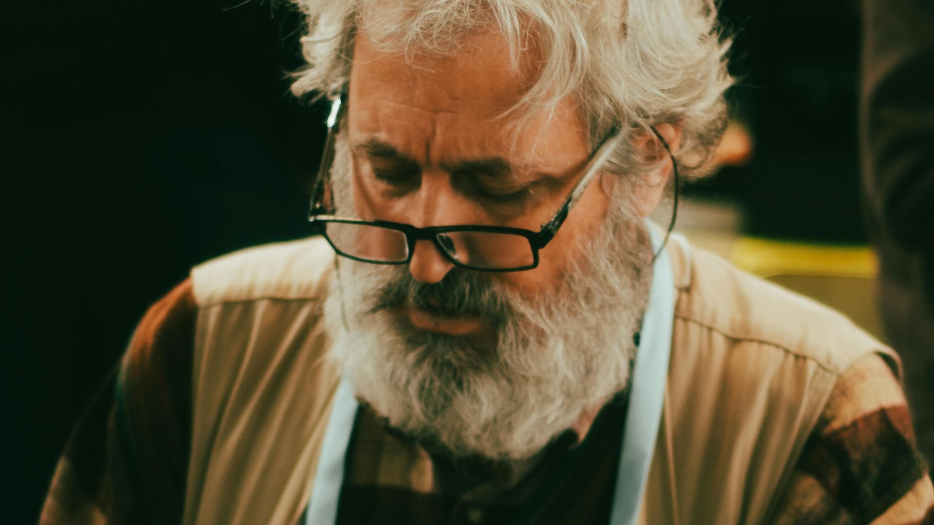 Senior artisan repairing clocks with tools, showcasing craftsmanship and precision.