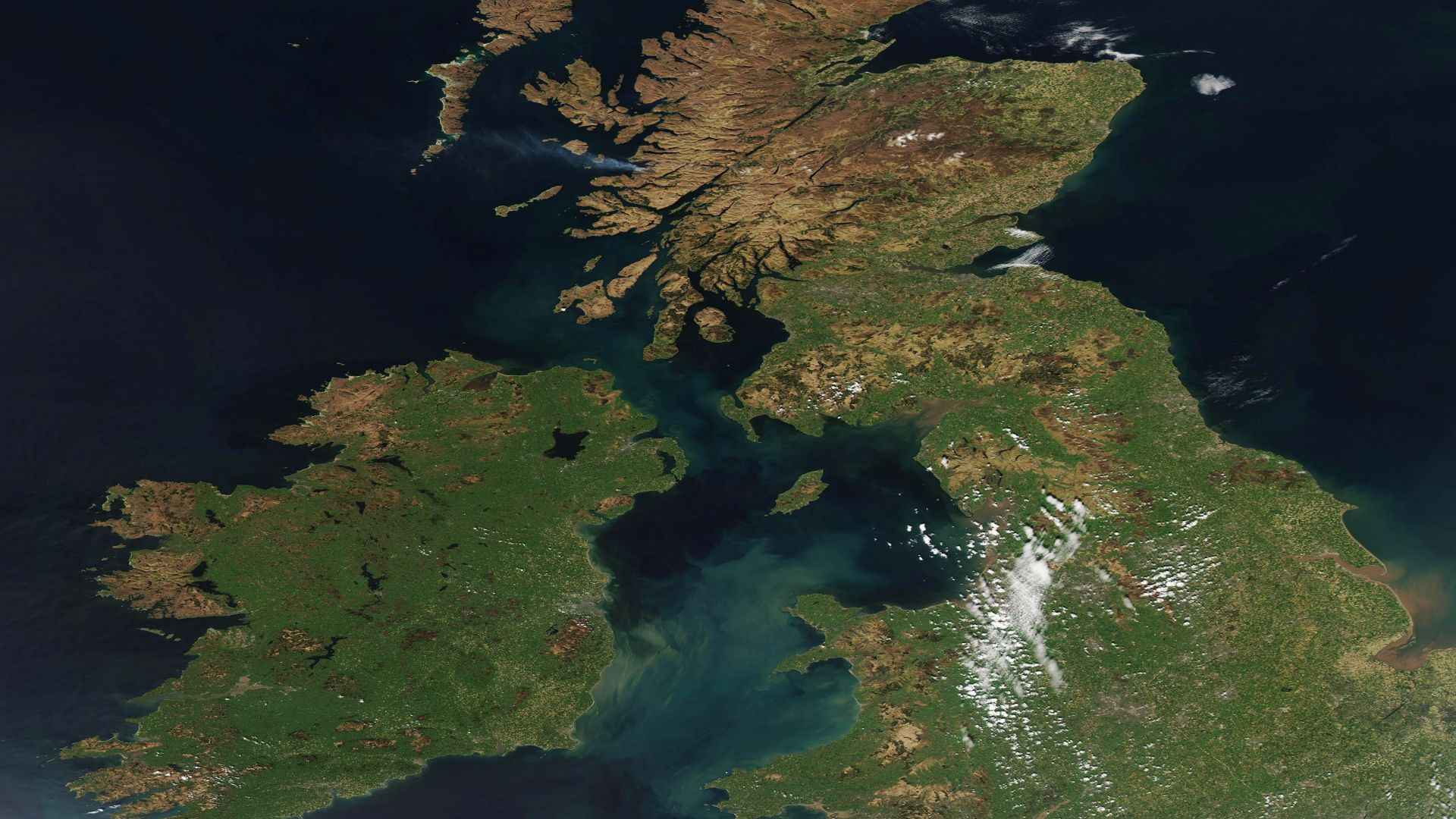 On April 20, 2023, a nearly cloud-free spring day allowed the Moderate Resolution Imaging Spectroradiometer (MODIS) on board NASA’s Aqua satellite to acquire a gorgeous true-color image of the United Kingdom and Ireland.
The United Kingdom (UK) stretches over both the large island of Great Britain and small islands surrounding it (east) and the northernmost section of the island of Ireland. Scotland, England, and Wales are located on Great Britain with Northern Ireland sitting on the northern sixth of the island of Ireland. The southern five-sixths of the island of Ireland belong to the country of Ireland. Sediment stains the waters of the Irish Sea, which separates the two islands.