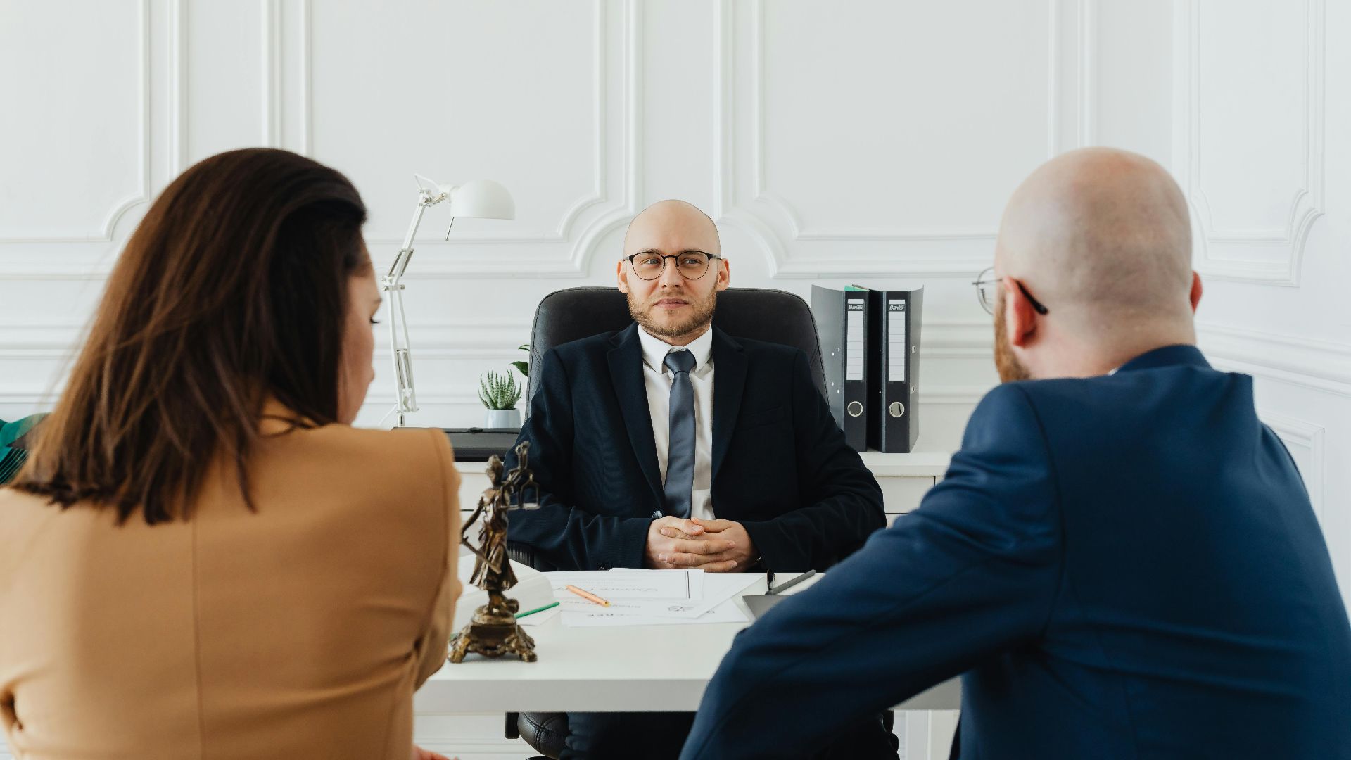 Lawyer meeting with clients in a formal office setting for legal consultation.