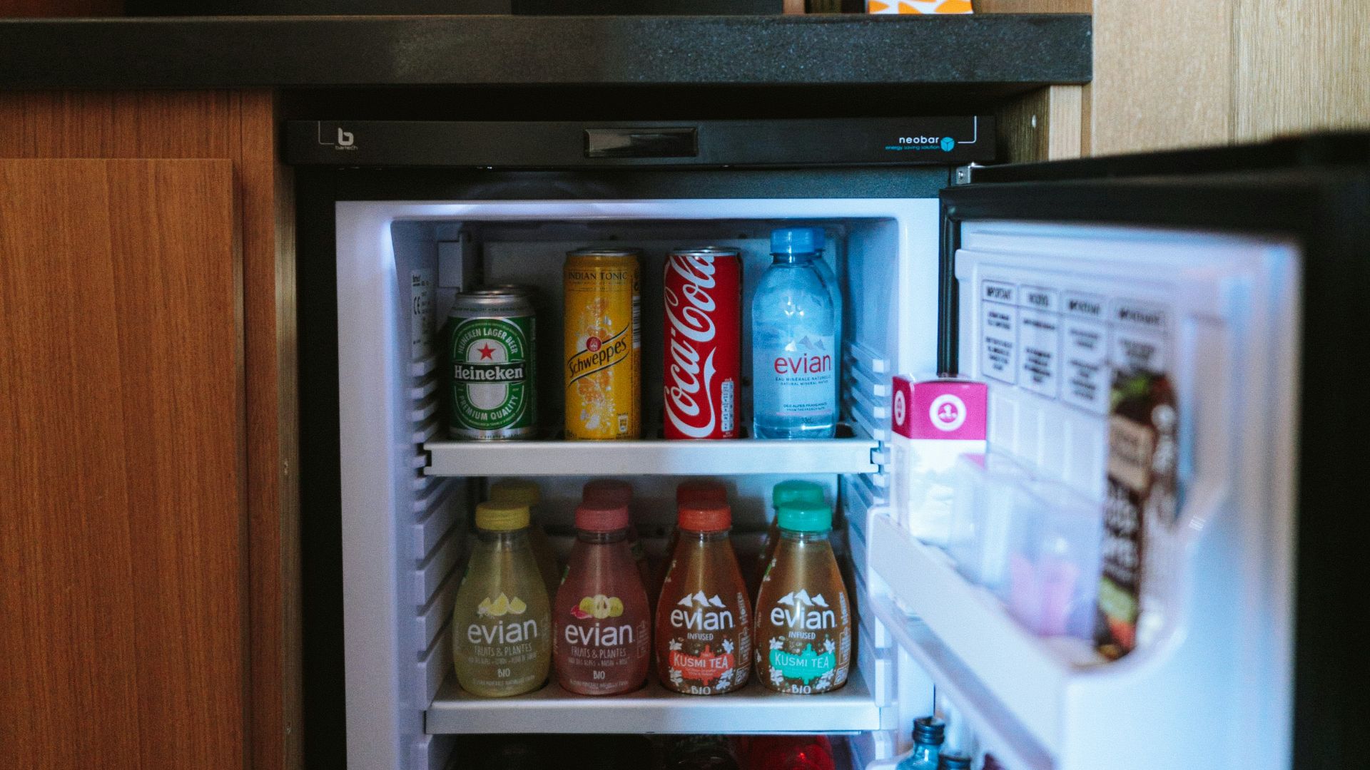 open black compact refrigerator filled with soda bottles