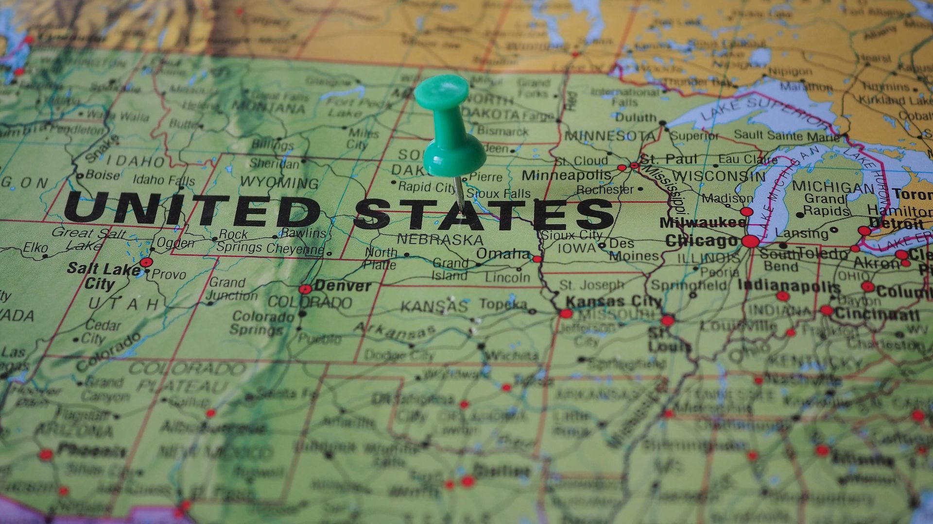 High-angle view of a map featuring the United States with a green pin indicating a specific location.