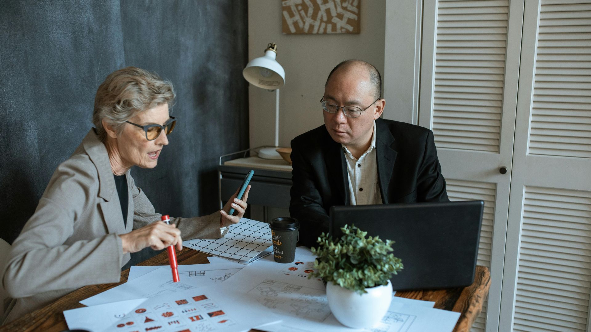 Two business professionals collaborating in a modern office setting for a project.