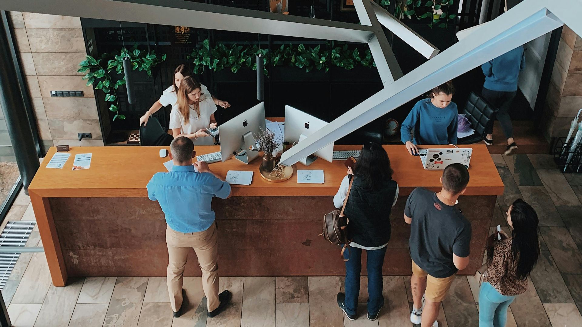 Aerial view of a modern hotel reception with people interacting at the desk in Sosnivka, Ukraine.