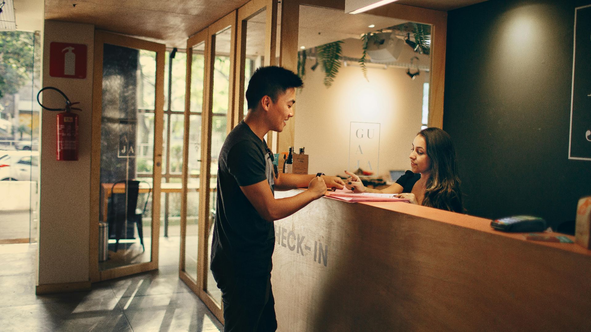 A customer checks in at a hotel reception desk in Belo Horizonte, Brazil.
