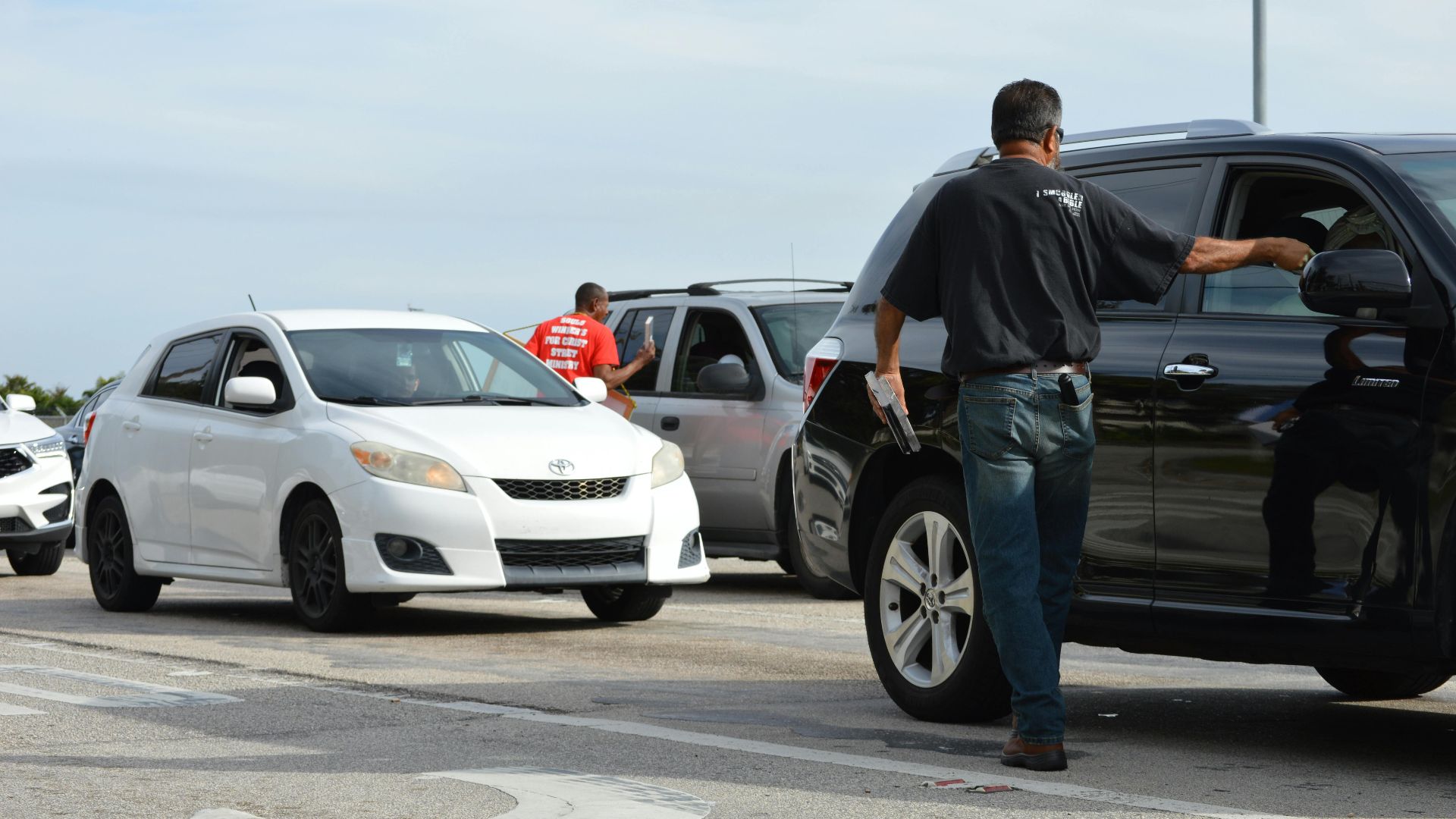 Traffic officer directing vehicles on a busy road intersection during daytime.