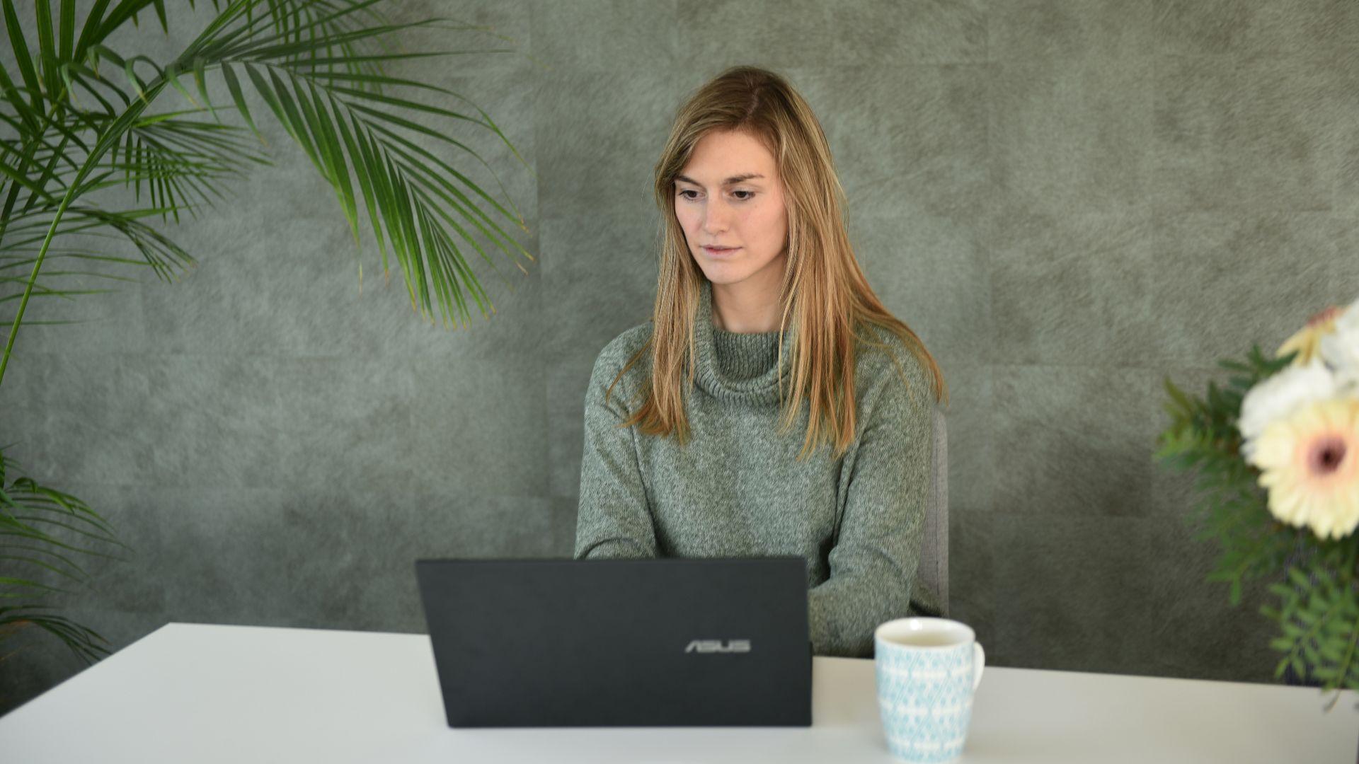 a woman sitting at a table with a laptop