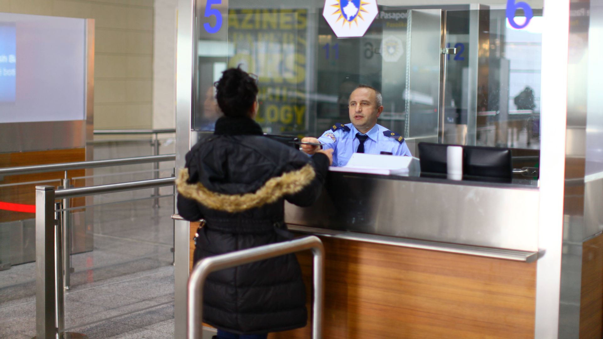 Kosovo Police Border Officer checking the passport of a traveler at the Prishtina International Airport.