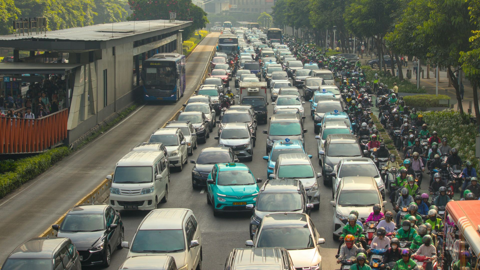 Dense traffic jam with buses and cars in a bustling city street during the day.