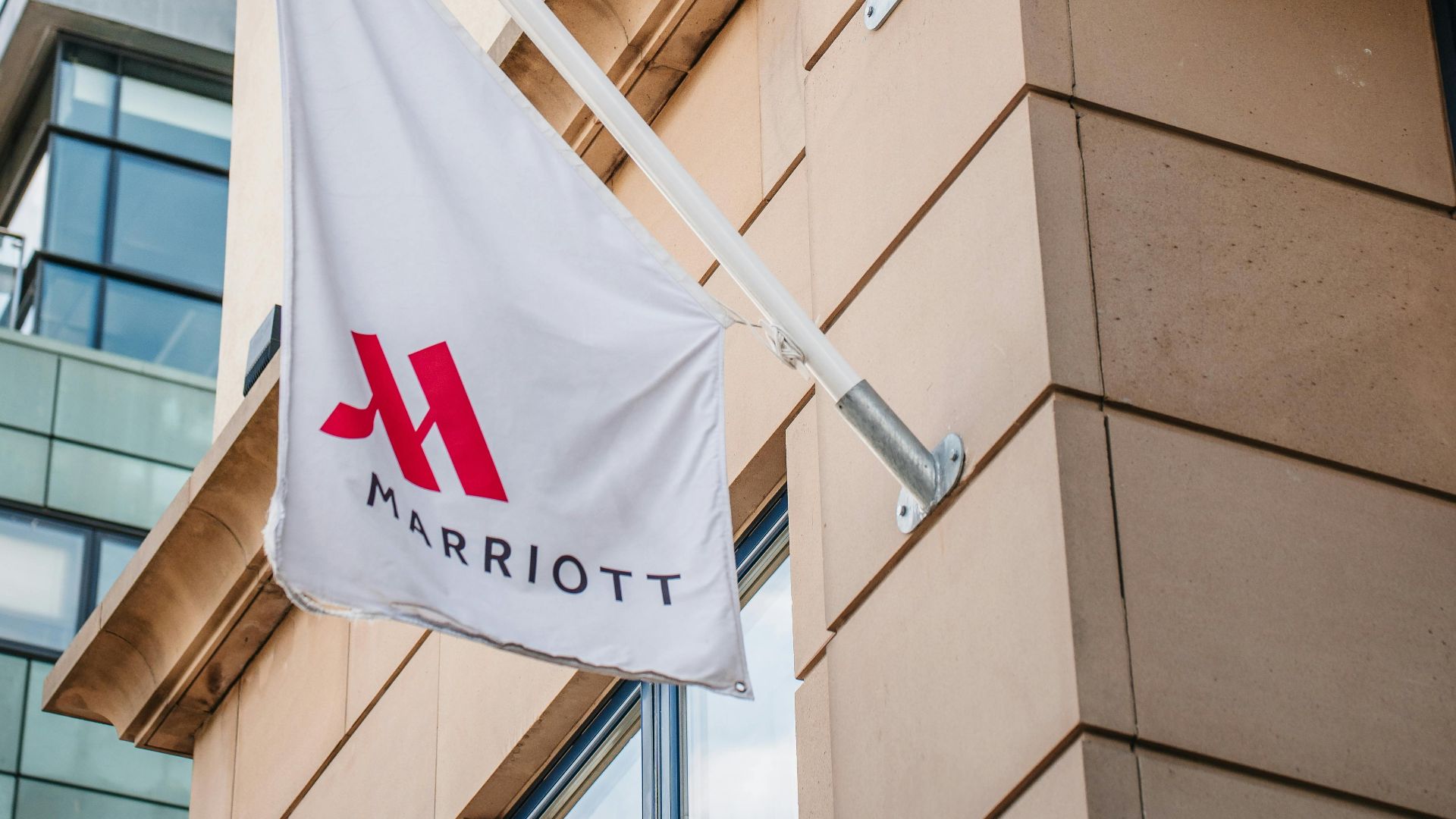 Exterior view of a Marriott Hotel with a logo flag displayed prominently.