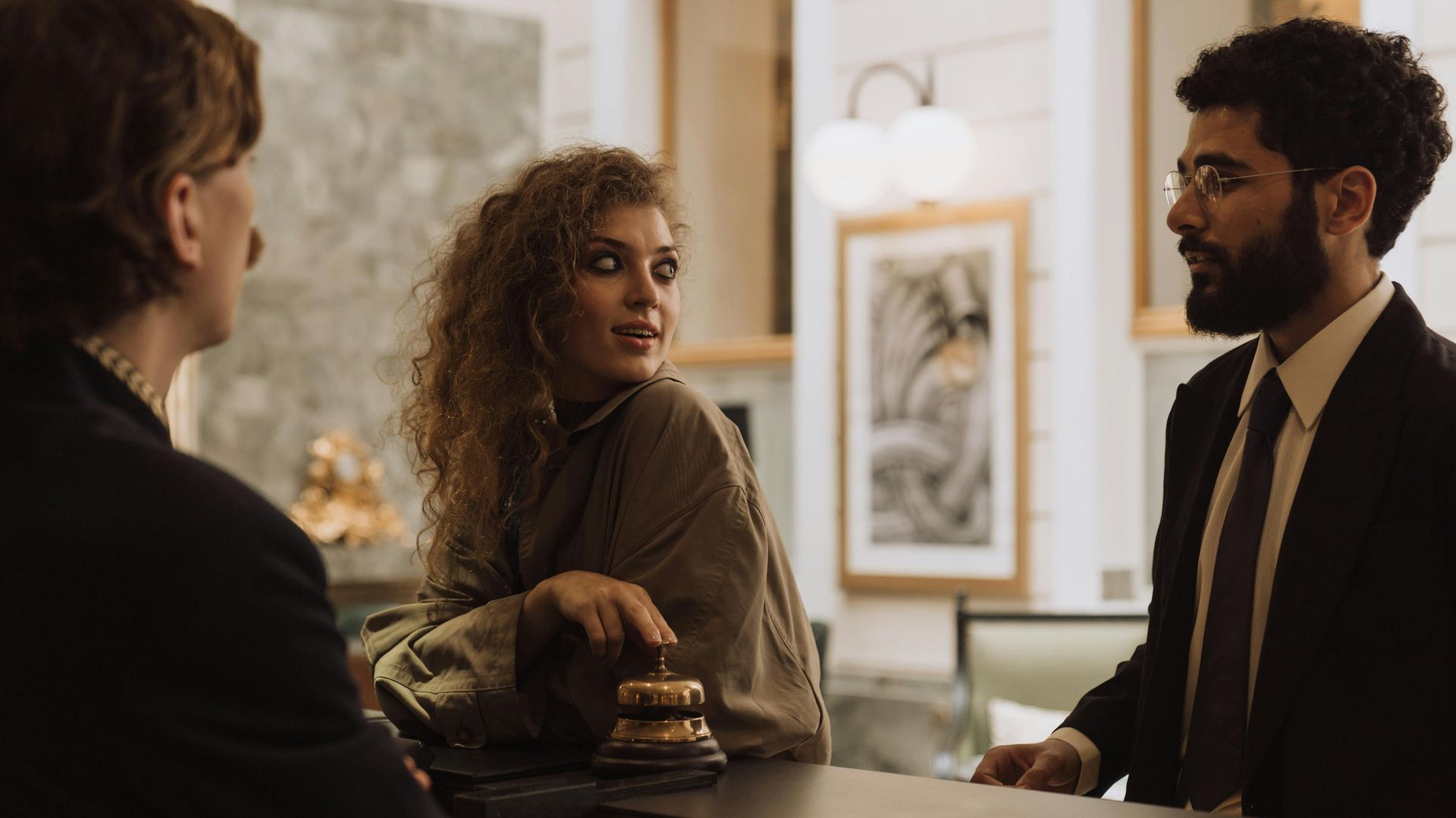 Guests interacting at a luxurious hotel reception desk, emphasizing hospitality and service.