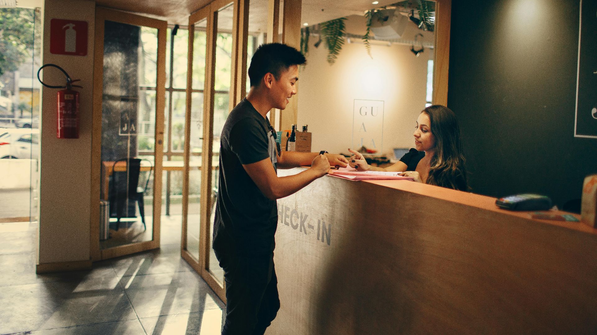 A customer checks in at a hotel reception desk in Belo Horizonte, Brazil.